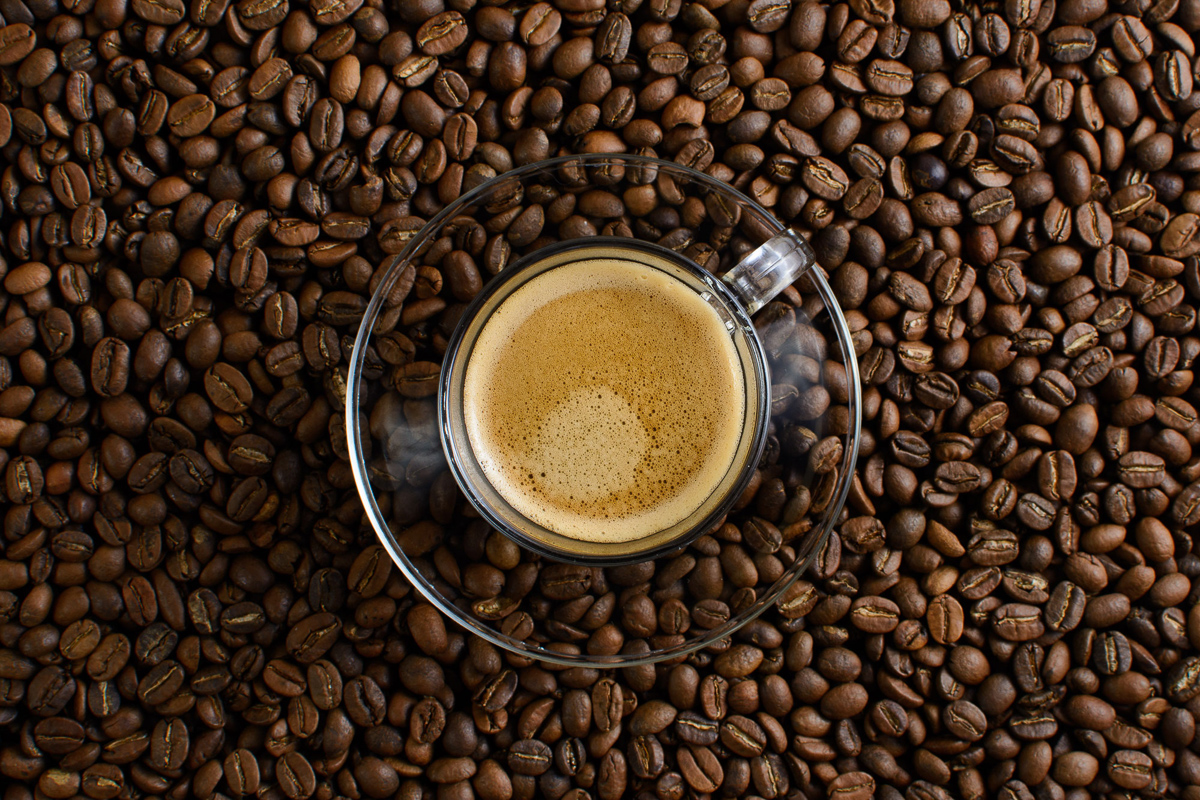 Taza de café espresso sobre granos tostados de café